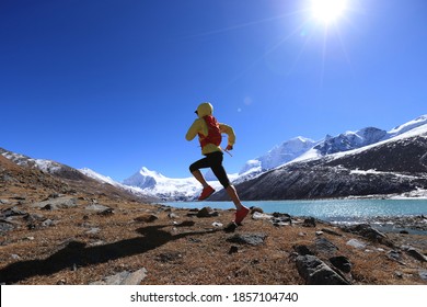 Woman trail runner cross country running  in winter mountains - Powered by Shutterstock