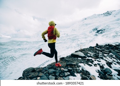 Woman Trail Runner Cross Country Running Up To Winter Snow Mountain Top