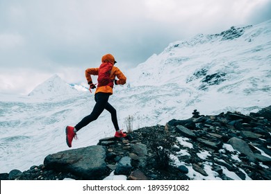 Woman Trail Runner Cross Country Running Up To Winter Snow Mountain Top