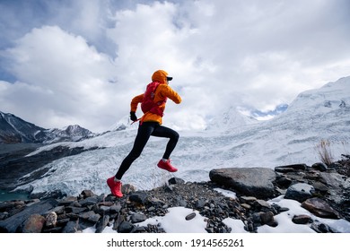 Woman Trail Runner Cross Country Running Up To Winter Snow Mountain Top