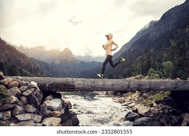 Woman trail runner cross country running in high altitude mountains 