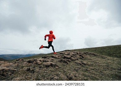 Woman trail runner cross country running to high altitude mountain peak - Powered by Shutterstock