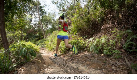 Woman Trail Runner Running In Forest