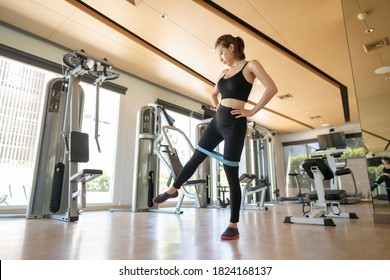 Woman Training Legs Muscles, Doing Side Leg Raise With Elastic Band In Gym.