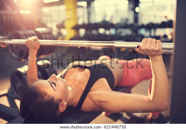 Woman training on bench\
press