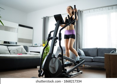 Woman Training On Elliptical Trainer At Home - Powered by Shutterstock