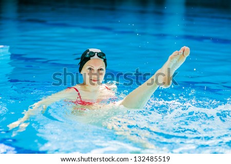 woman trains synchronous swimming at water pool