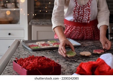 Woman Is Transferring Christmas Cookies From Baking Sheet To Cooling Rack