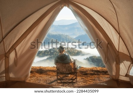 Woman travel and camping at mountain natural park near city Dalat, Vietnam. Recreation and journey outdoor activity lifestyle. View from the tent.