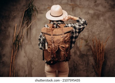 Woman With Travel Canvas Backpack And Felt Hat On Dark Background, Back View.