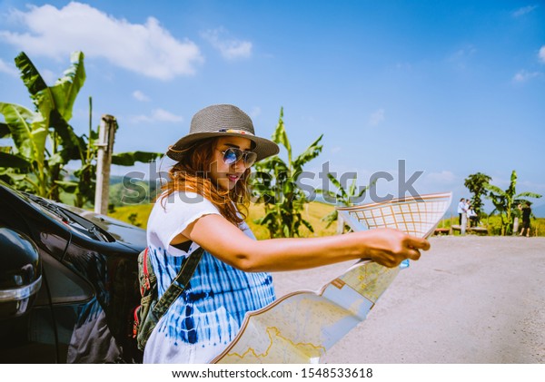 woman travel relaxing\
nature mountain map navigation. Travel relax in the holiday. View\
map travel explore. The girl standing view map travel explore\
beside the car. In\
Thailand