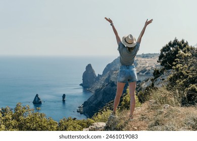 Woman travel sea. Happy tourist in hat enjoy taking picture outdoors for memories. Woman traveler posing on the beach at sea surrounded by volcanic mountains, sharing travel adventure journey - Powered by Shutterstock