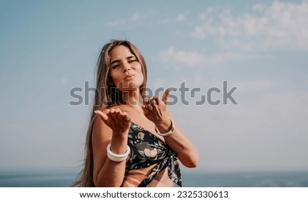 Woman travel sea. Happy tourist taking picture outdoors for memories. Woman traveler looks at the edge of the cliff on the sea bay of mountains, sharing travel adventure journey