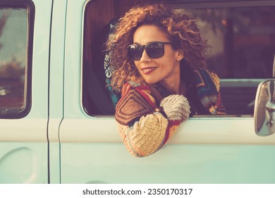 Woman travel with vehicle and looking outside the window smiling and enjoying road trip alone. Concept of classic van renting vacation people tourism lifestyle. Pretty cute adult female passenger - Powered by Shutterstock