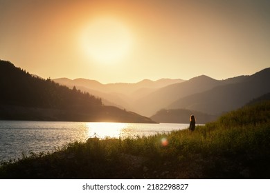 Woman Traveler Admiring The Sunset On The Shore Of A Lake In The Mountains. Tara National Park, Travel To Serbia