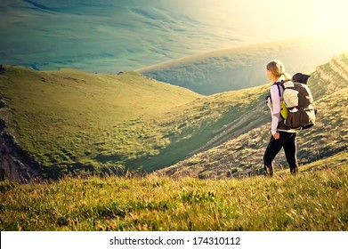 Woman Traveler with Backpack hiking in Mountains with beautiful summer landscape on background mountaineering sport lifestyle concept