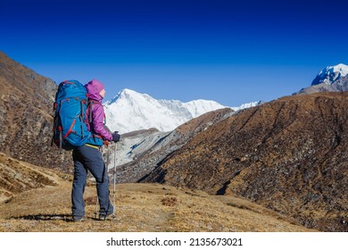 Woman Traveler With Backpack Hiking In Mountains With Beautiful Summer Himalayas Landscape On Background. Everest Base Camp Trek. Cho Oyu Mountain On The Background