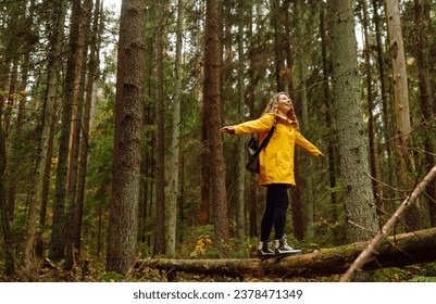 Woman traveler in a bright coat walks along a wooden path among the wetlands. A tourist with a backpack walks through the forest. Travel, nature concept. - Powered by Shutterstock