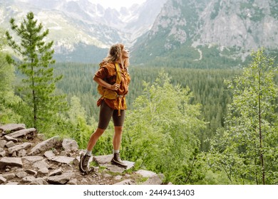 Woman traveler enjoying beautiful view of mountains. Beautiful mountains landscape view. Lifestyle, adventure, nature, active life. - Powered by Shutterstock