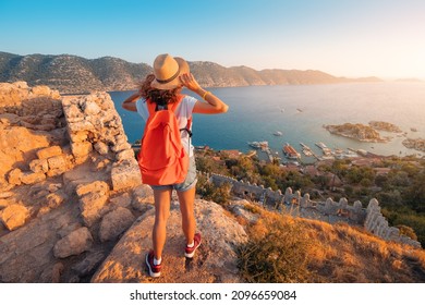 Woman traveler explores the ruins of the castle of Simena with a view of the sea bay and Kekova Island with the famous flooded city. Tourist attractions in Turkey - Powered by Shutterstock