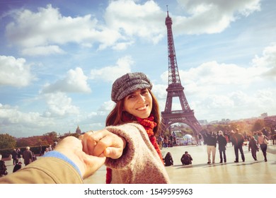 Woman traveler leading photographer to see Eiffel Tower in Paris.