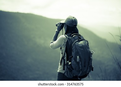 woman traveler looking through binoculars 