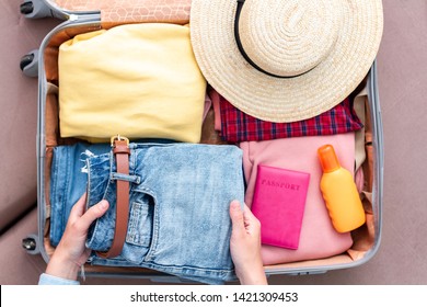 Woman Traveler Packing Clothes In A Suitcase For A New Journey. Luggage For Travel Holidays And Vacation. Top View 