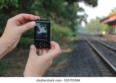 woman traveler photographed railway on a small camera.