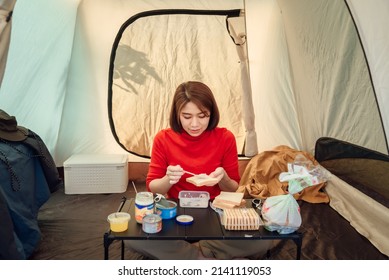 A Woman Traveler Is Preparing Sandwiches For Her Dinner Inside The Tent.