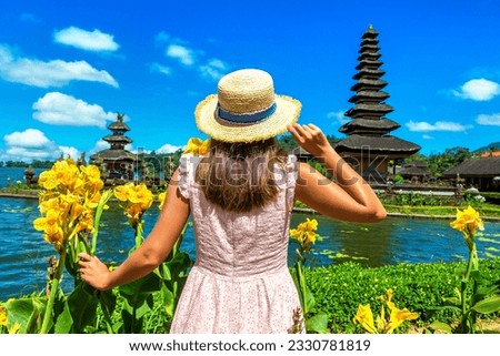 Woman traveler at  Pura Ulun Danu Beratan Bedugul temple on a lake in Bali, Indonesia