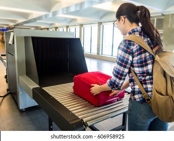 woman traveler selective focus Baggage X-ray machine try to detection metal prevention bad terrorist to attack airplane at the airport before take off.