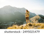 Woman Traveler standing at mountains with backpack admiring landscape. Travel Lifestyle. Concept adventure summer vacations outdoor.