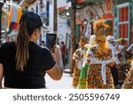 Woman traveler taking pictures of Antioquian village culture. Guatape. Dance and tradition.