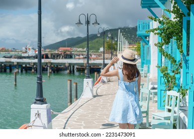 Woman traveler visiting at Son Tra marina. Tourist with blue dress and hat traveling in Da Nang city. Vietnam and Southeast Asia travel concept