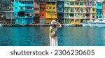 woman traveler visiting in Taiwan, Tourist with backpack and hat sightseeing in Keelung, Colorful Zhengbin Fishing Port, landmark and popular attractions near Taipei city . Asia Travel concept
