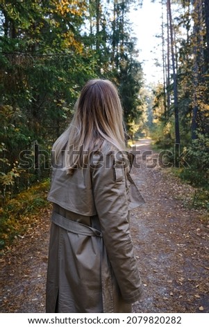 A woman traveler walks through the forest. Beautiful nature landscape in woods. Hiking journey on tourist trail. Outdoor adventure. Travel and exploration. Healthy lifestyle, leisure activities