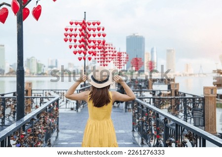 Woman Traveler with yellow dress visiting in Da Nang. Tourist sightseeing at love lock bridge. Landmark and popular. Vietnam and Southeast Asia travel concept