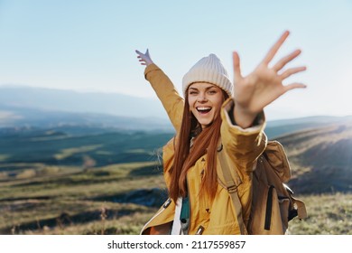 woman traveler in a yellow jacket in a hat backpack travel mountains Fresh air - Shutterstock ID 2117559857