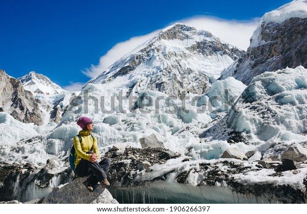 Woman\
Travelerh hiking in Himalaya mountains with mount Everest, Earth\'s\
highest mountain. Travel sport lifestyle\
concept