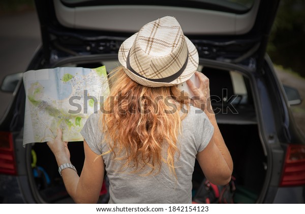 woman\
traveling by car with mobile phone and\
map
