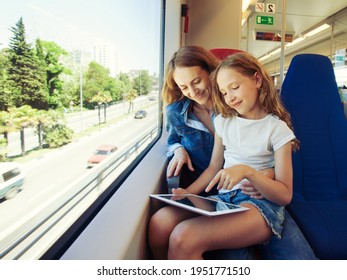 Woman traveling by pablic transport. Beautiful young female travelling in a train and looking through the window 