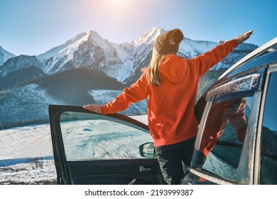 Woman traveling exploring, enjoying the view of the mountains, landscape, lifestyle concept winter vacation outdoors. Female standing near the car in sunny day, travel in the mountains, freedom - Shutterstock ID 2193999387
