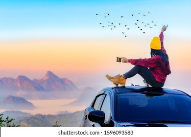 Woman traveller enjoy coffee time on her owns roof of the car with scenery view of the mountain and mist morning in background - Powered by Shutterstock