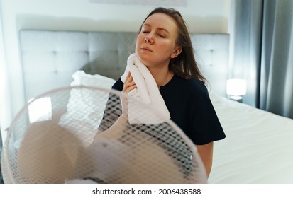 Woman Tries To Cool Off During The Intense Heat In Front Of Cooling Fan.