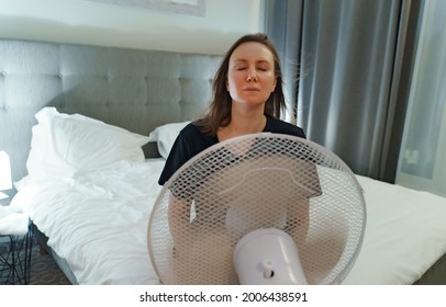 Woman Tries To Cool Off During The Intense Heat In Front Of Cooling Fan.