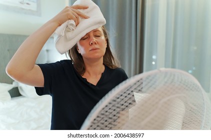 Woman Tries To Cool Off During The Intense Heat In Front Of Cooling Fan.