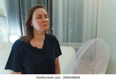 Woman Tries To Cool Off During The Intense Heat In Front Of Cooling Fan.