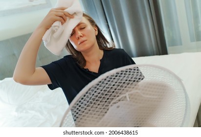 Woman Tries To Cool Off During The Intense Heat In Front Of Cooling Fan.