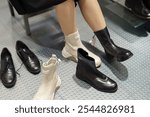 A woman tries on black and white boots in a shoe store.