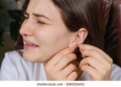 A Woman Tries To Put An Earring In Her Ear, Earlobe Problem, The Hole Is Overgrown